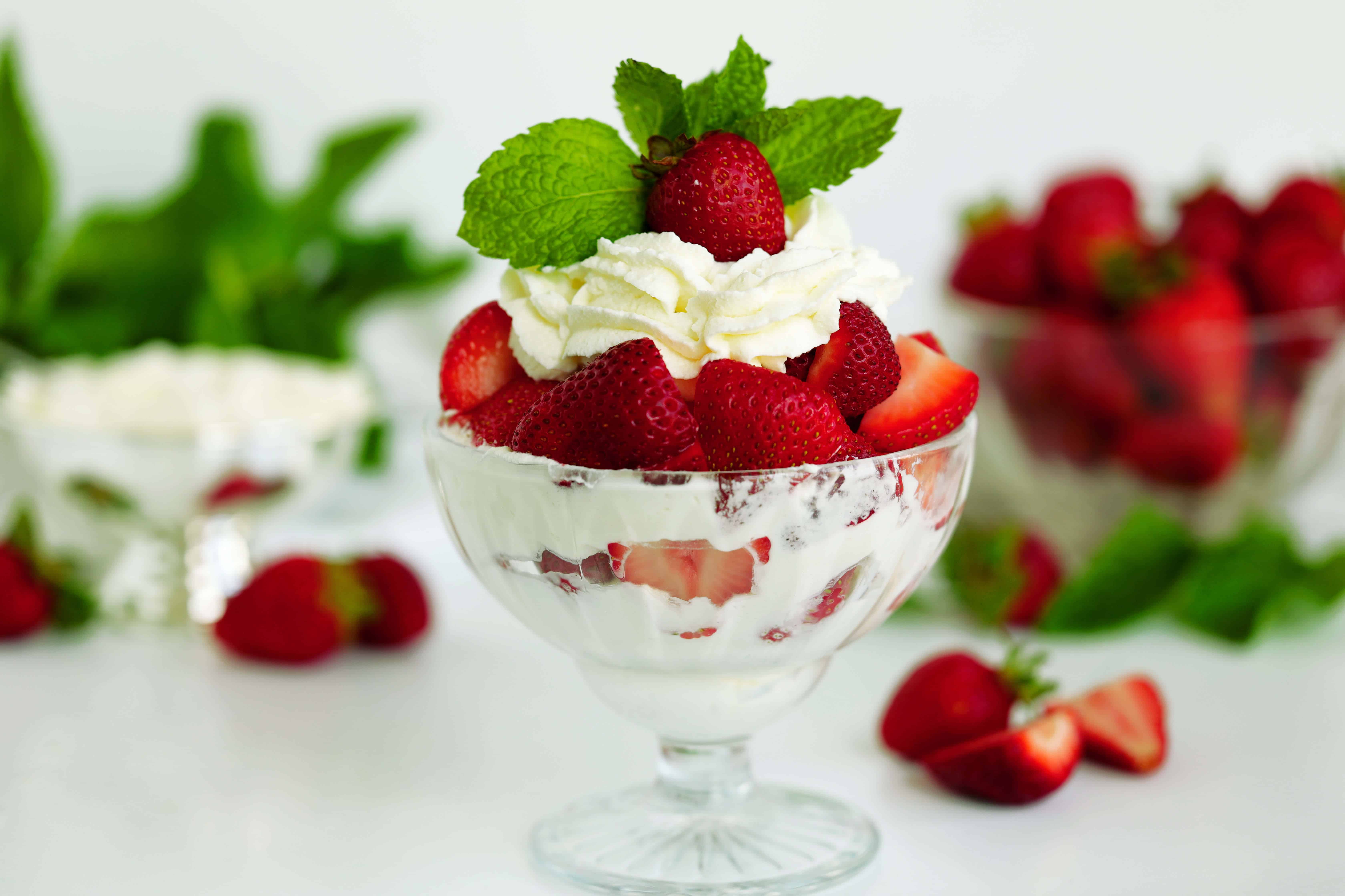 Strawberries and Cream in a dessert bowl, garnished with fresh mint