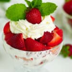 A close-up of Strawberries and Cream in a dessert bowl, garnished with fresh mint