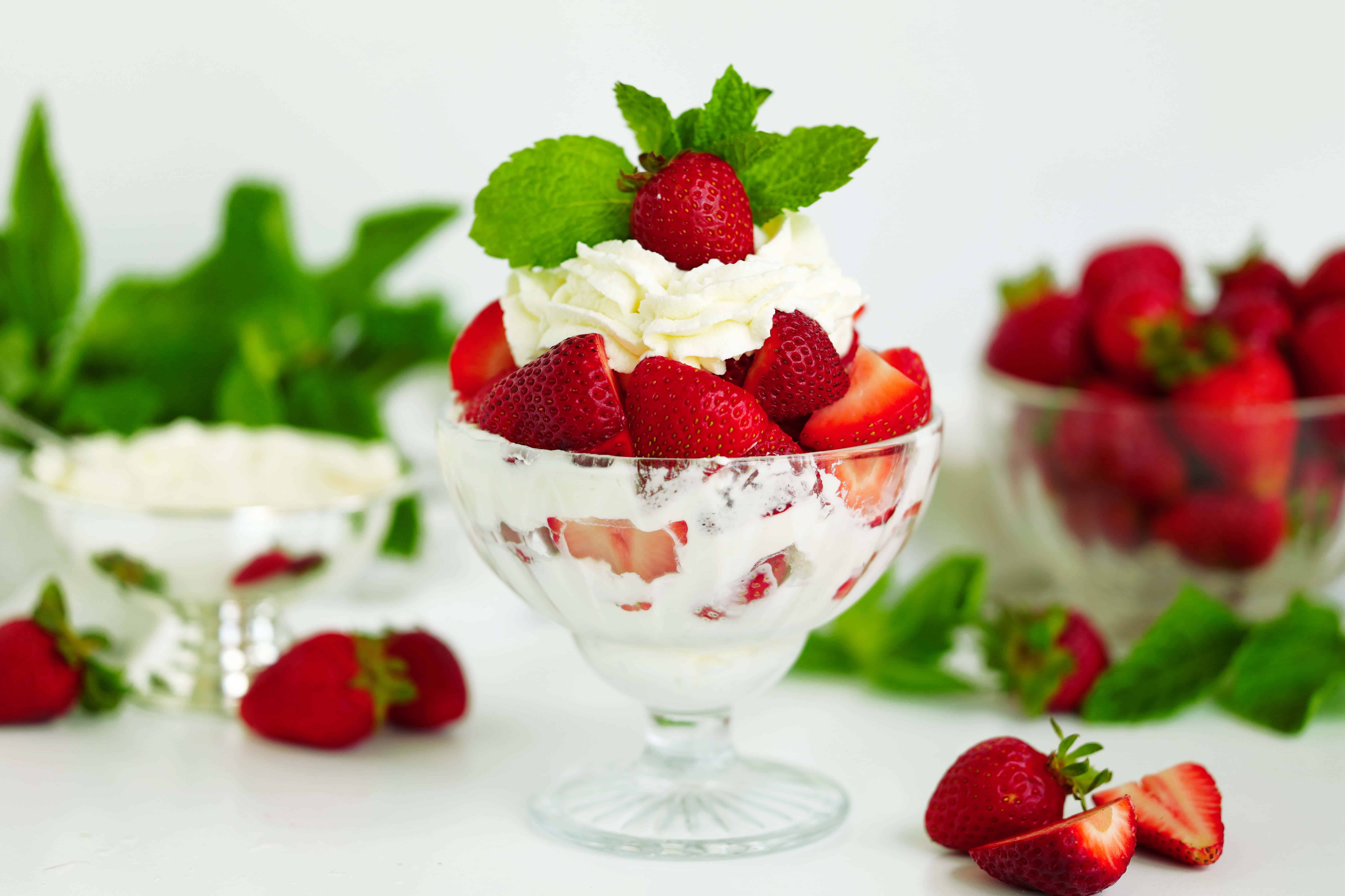 Strawberries and Cream in a dessert bowl, garnished with fresh mint