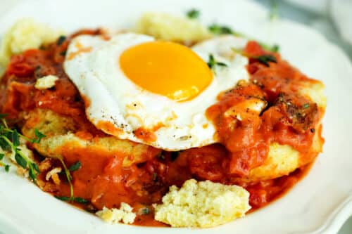Biscuits and a fried eggs topped with Tomato Gravy