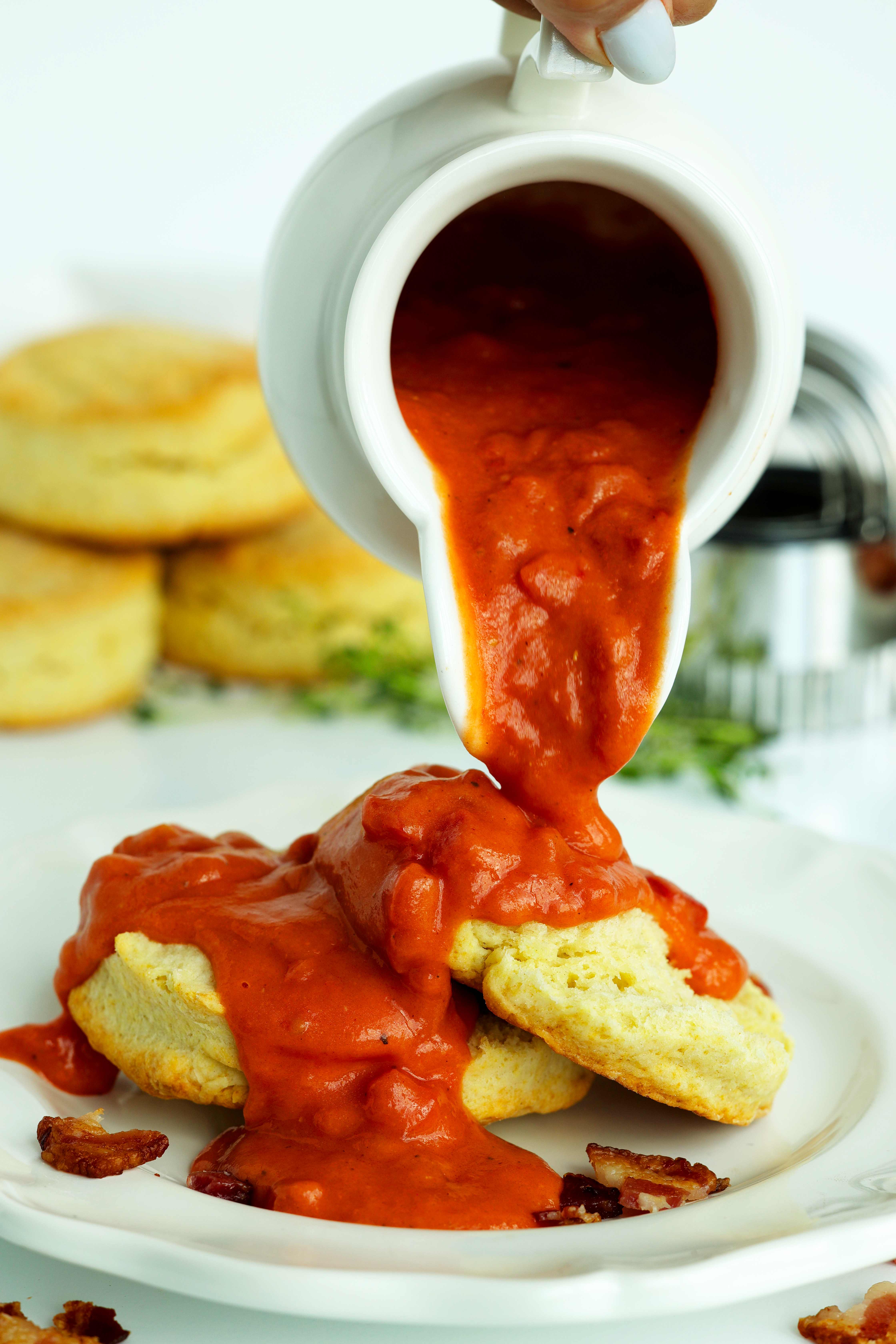 Tomato Gravy being poured over biscuits