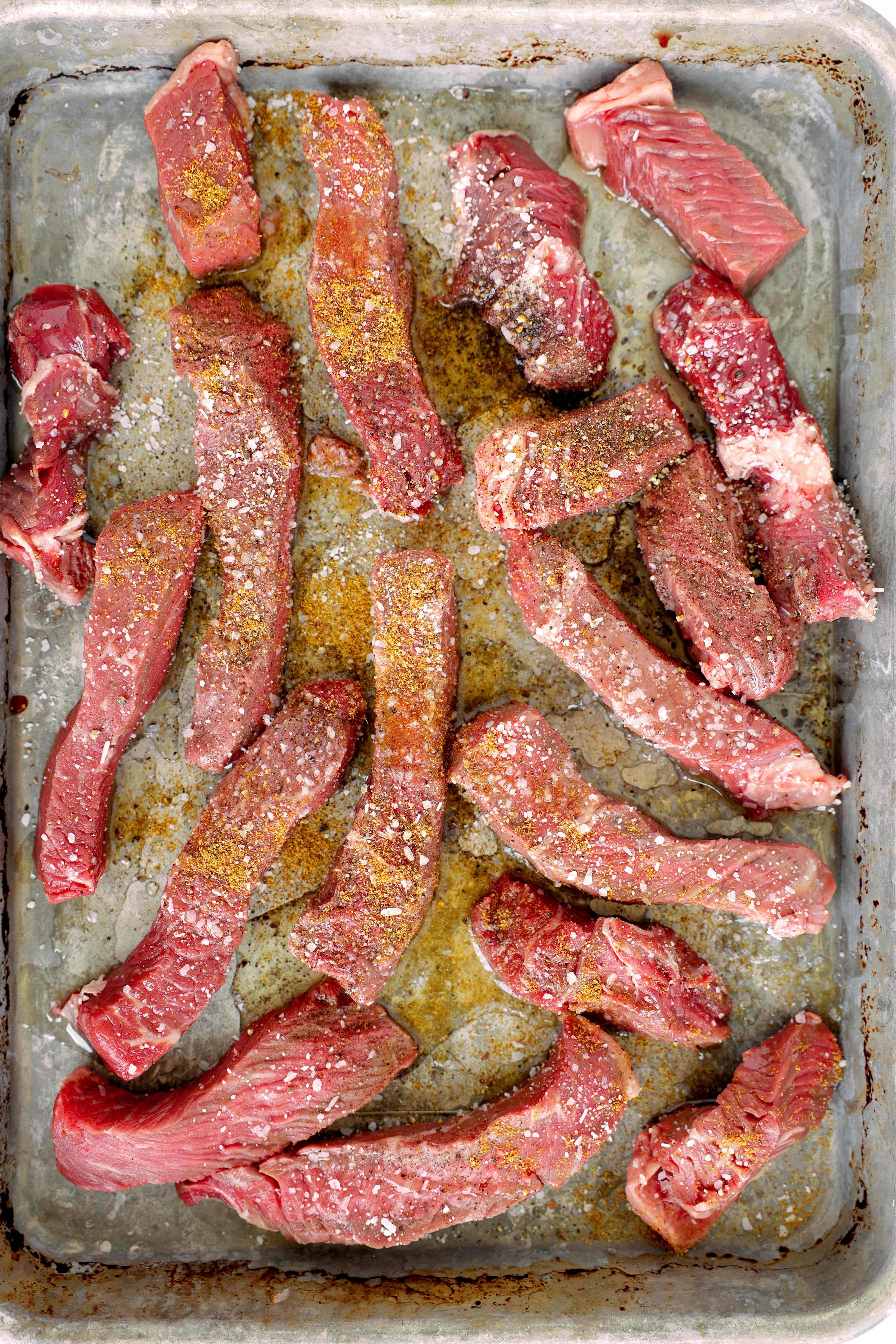 Overhead shot of uncooked bistec steak on a sheet pan