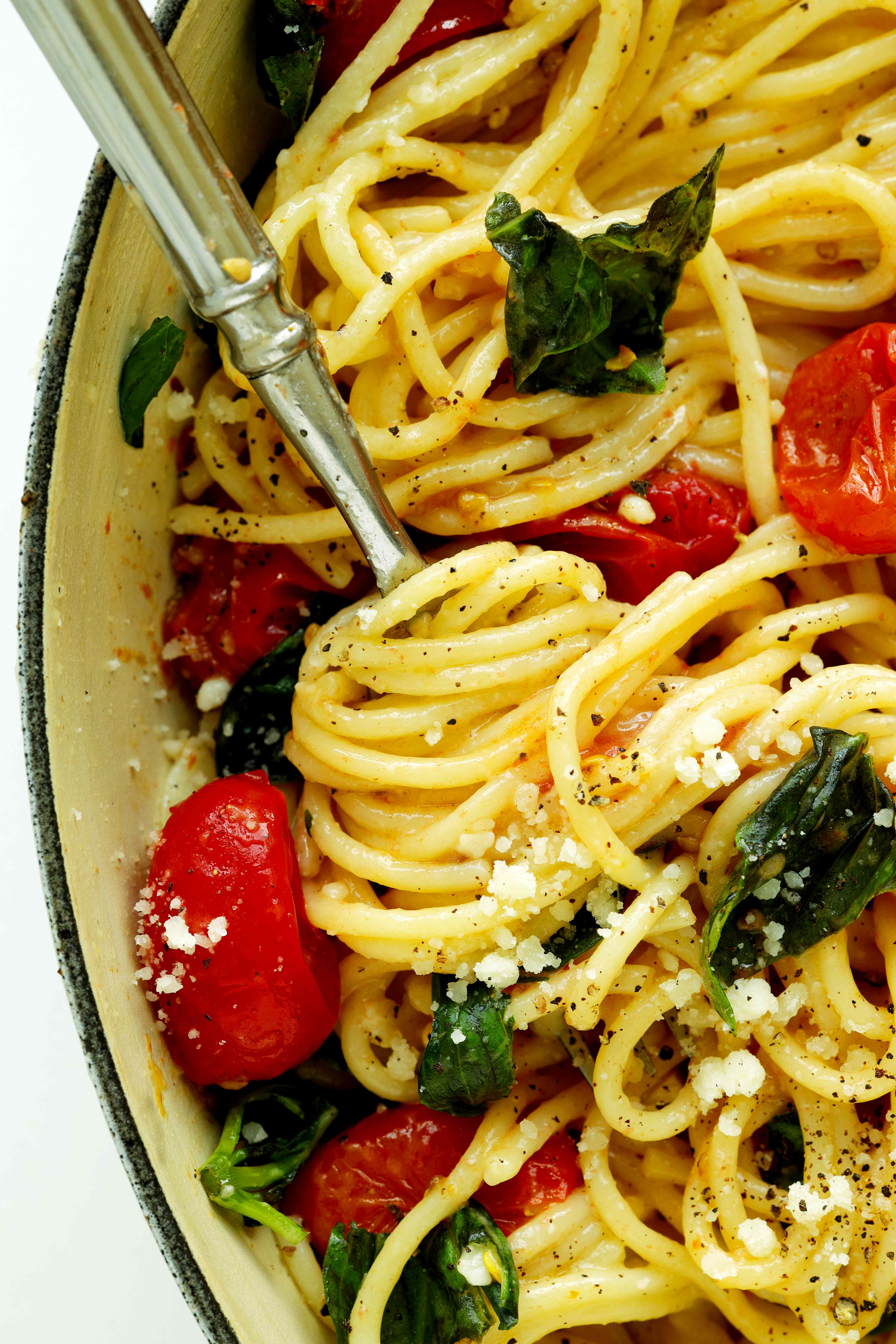 Overhead, closeup shot of Chery Tomato Pasta in a Dutch oven with noodles wrapped around a fork