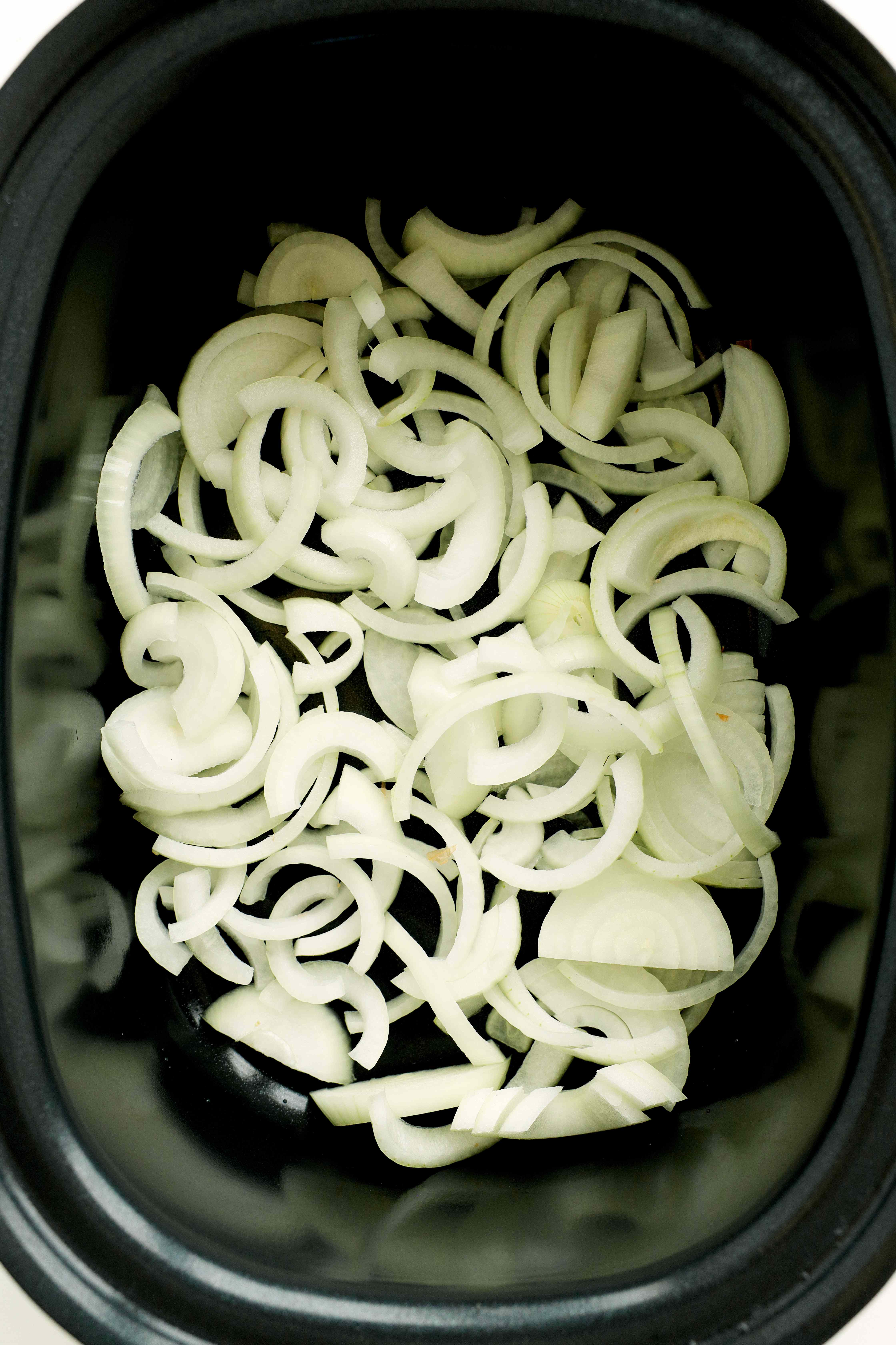 Sliced onions in the slow cooker for Country-Style Pork Ribs