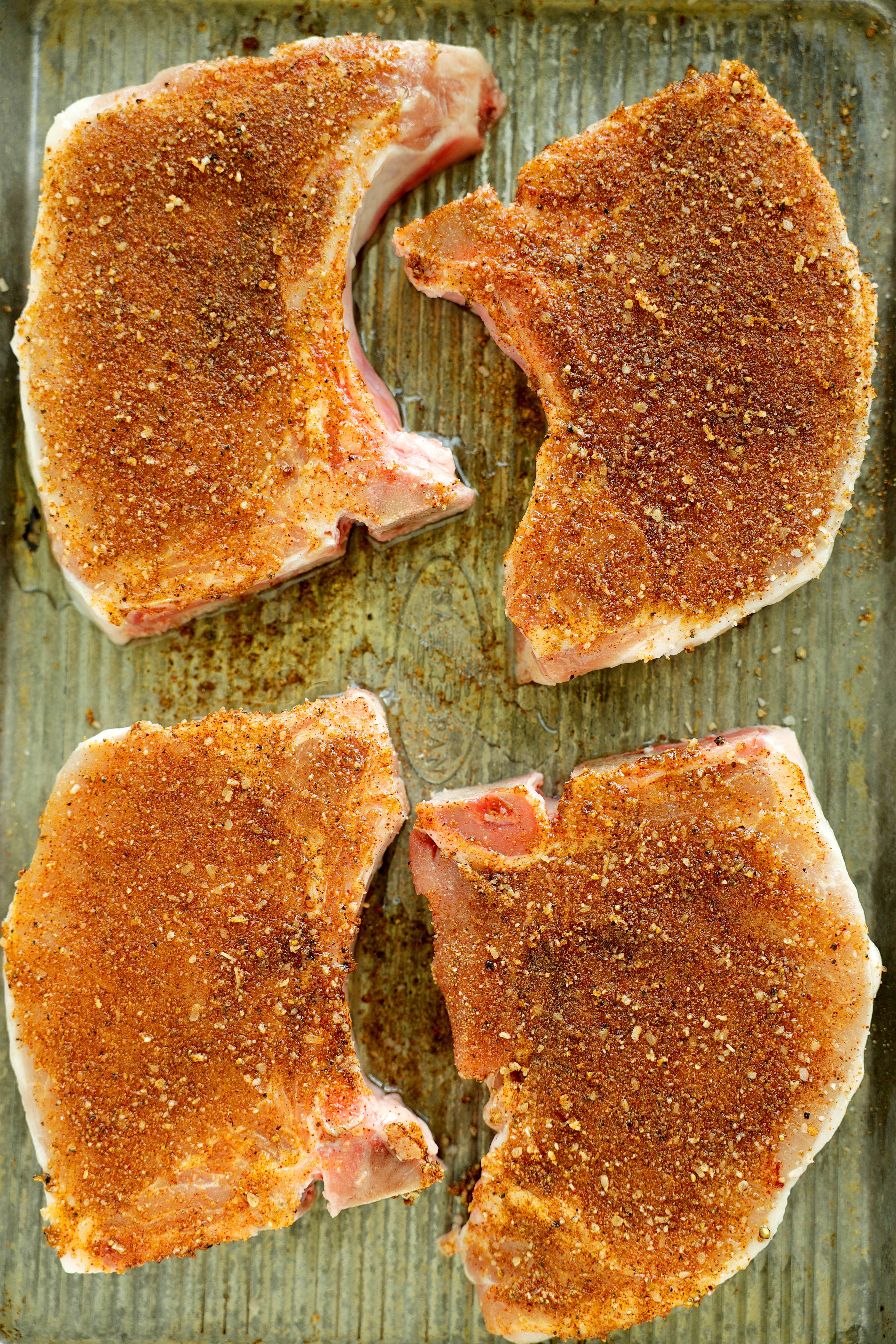 Pork Chops seasoned with Pork Chop Seasoning on a sheet pan