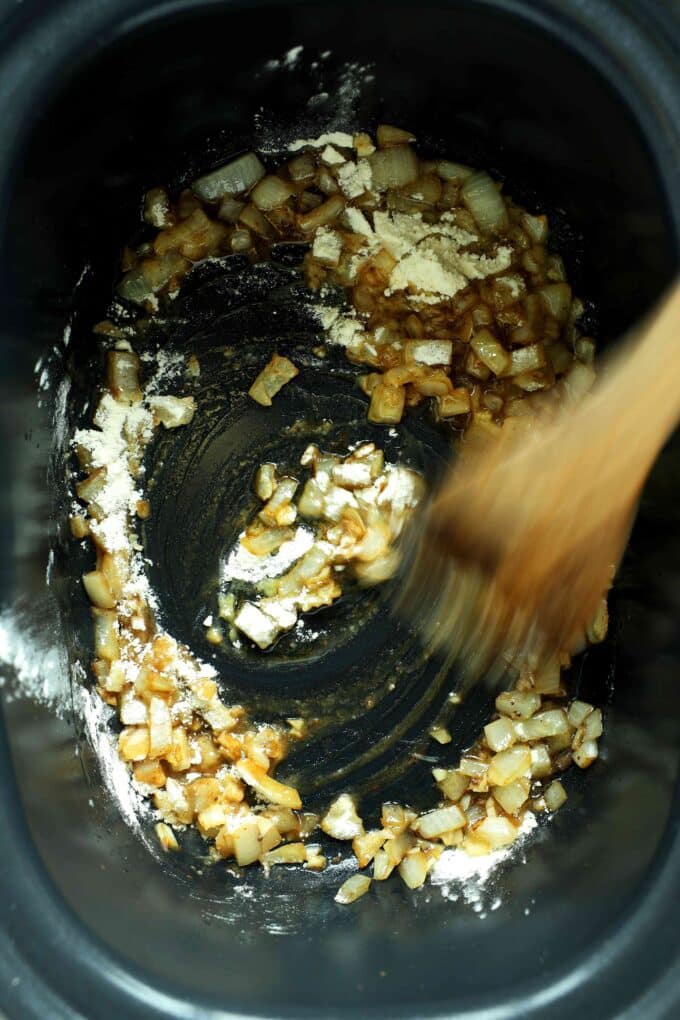 Adding flour to onions and garlic in the crockpot for beef tips and gravy
