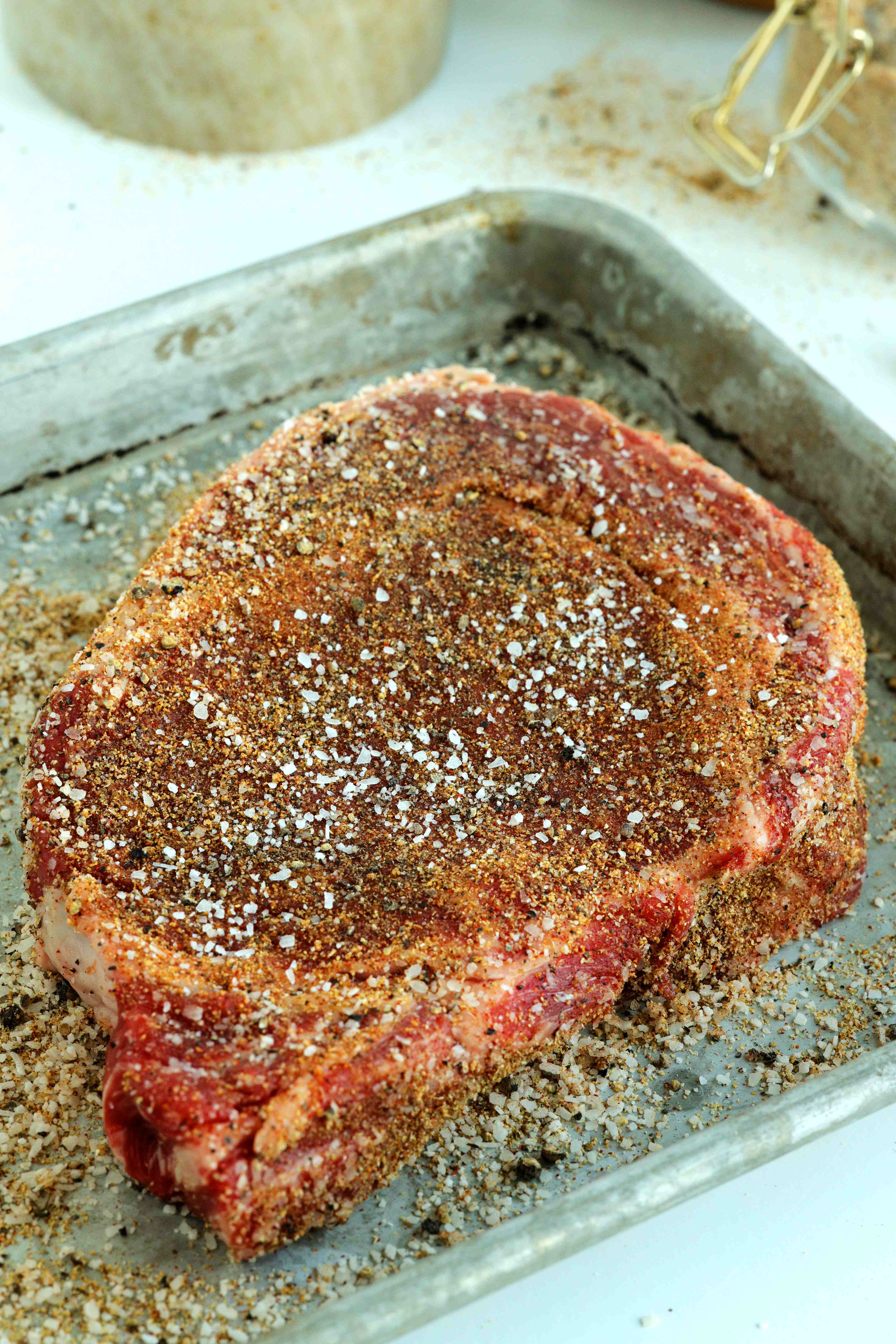Homemade seasoning for steak on an uncooked cut of beef