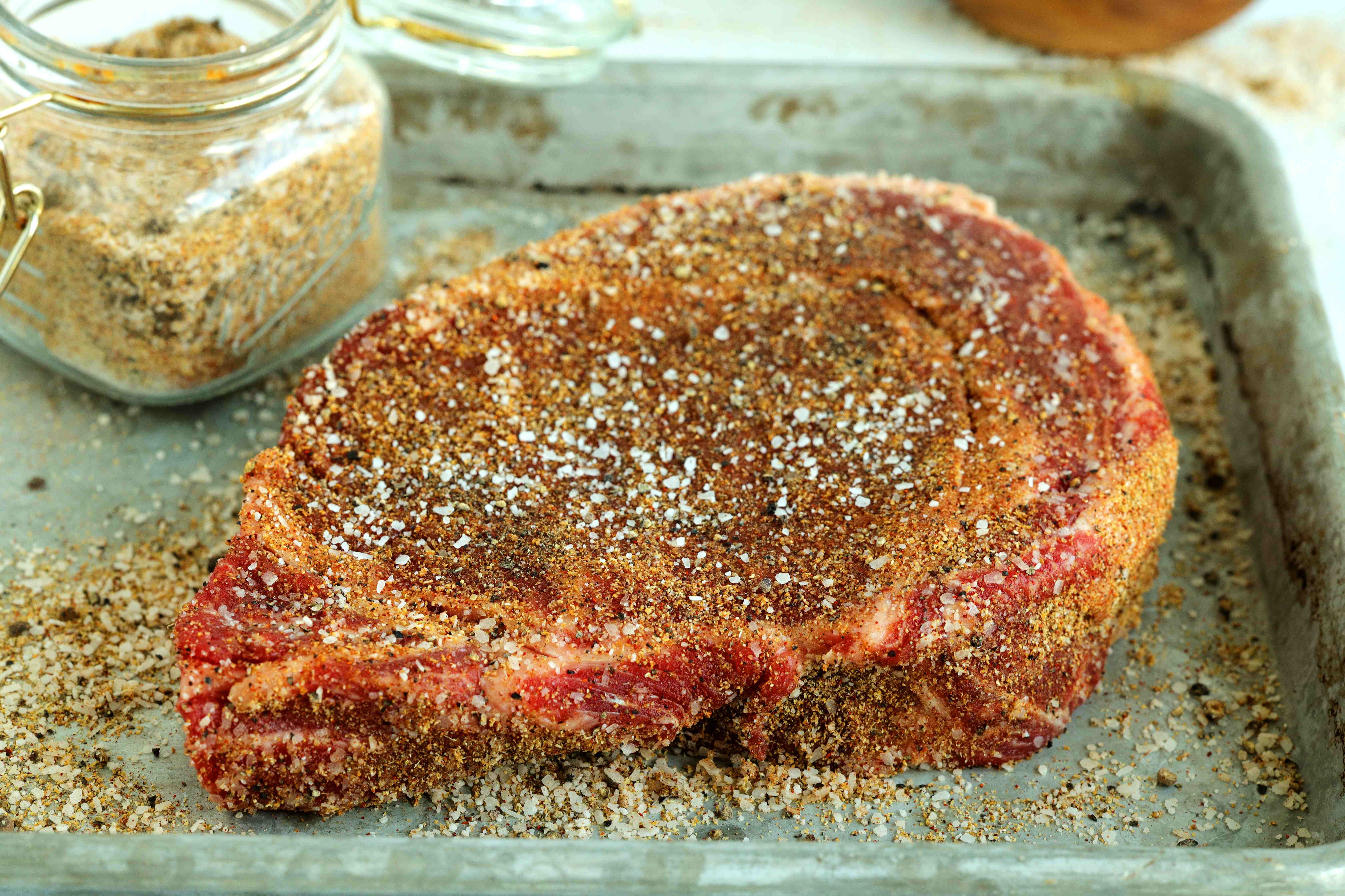 Homemade seasoning for steak on an uncooked cut of beef