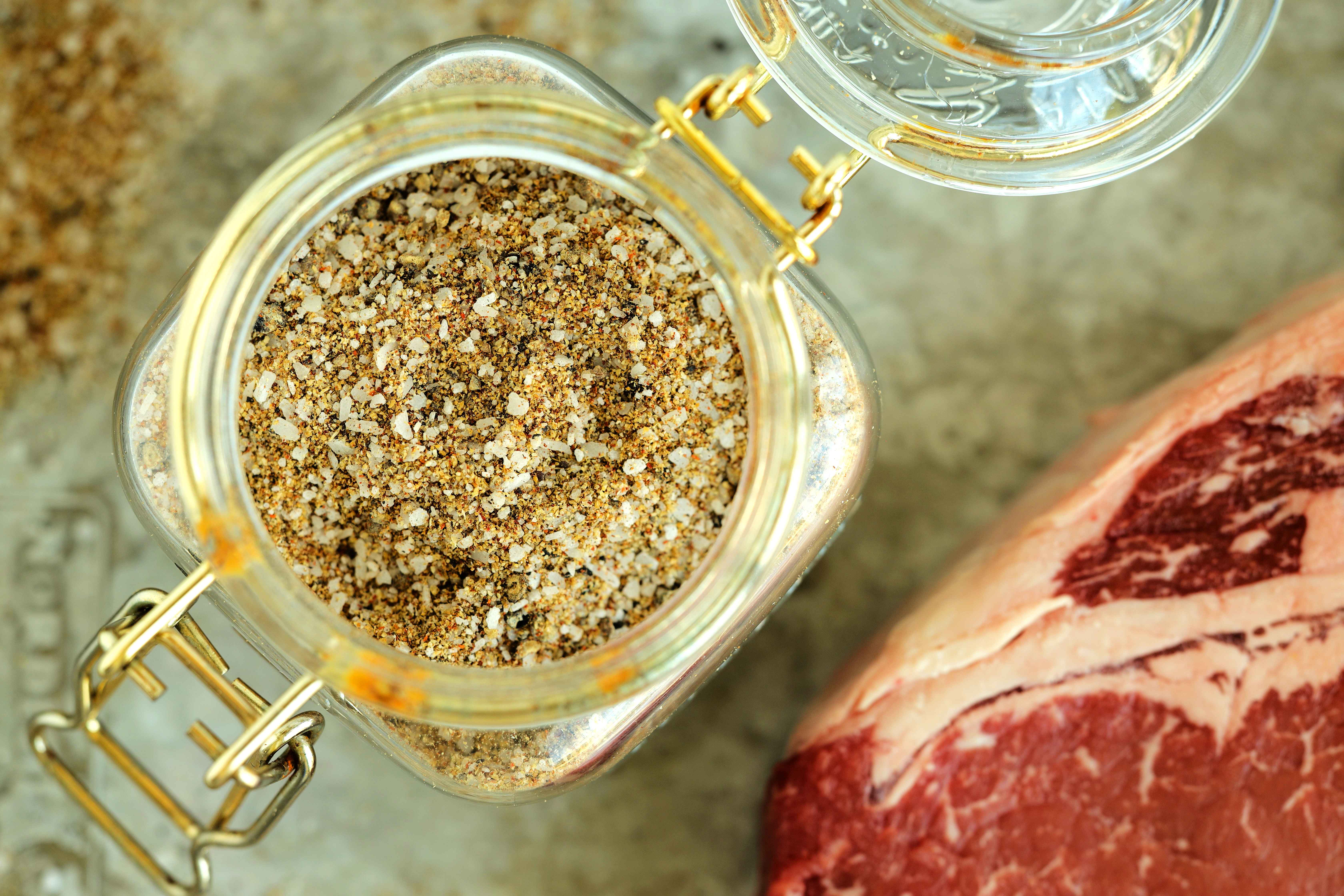Overhead shot of steak seasoning in a glass storage container