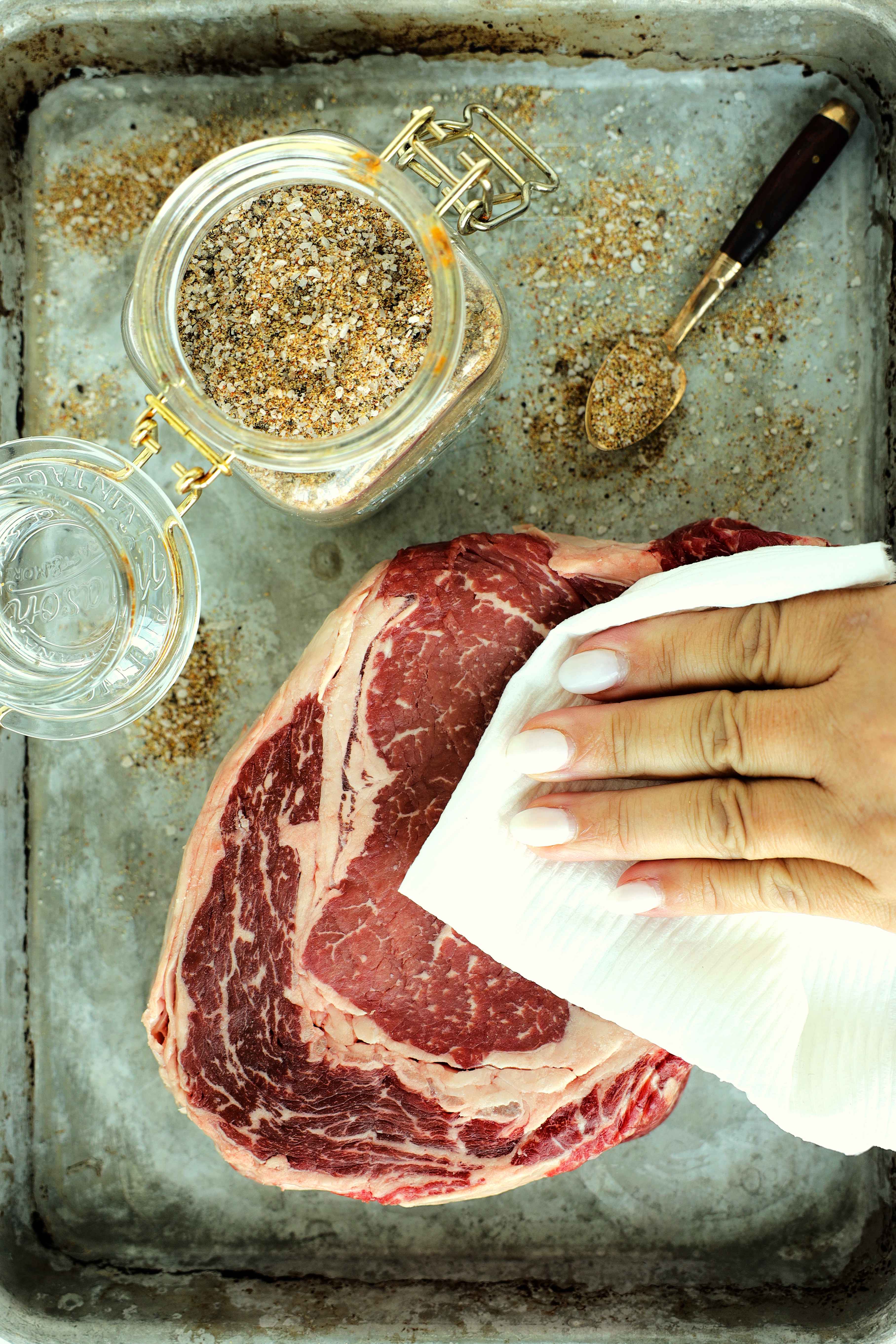 Patting a steak dry with a paper towel