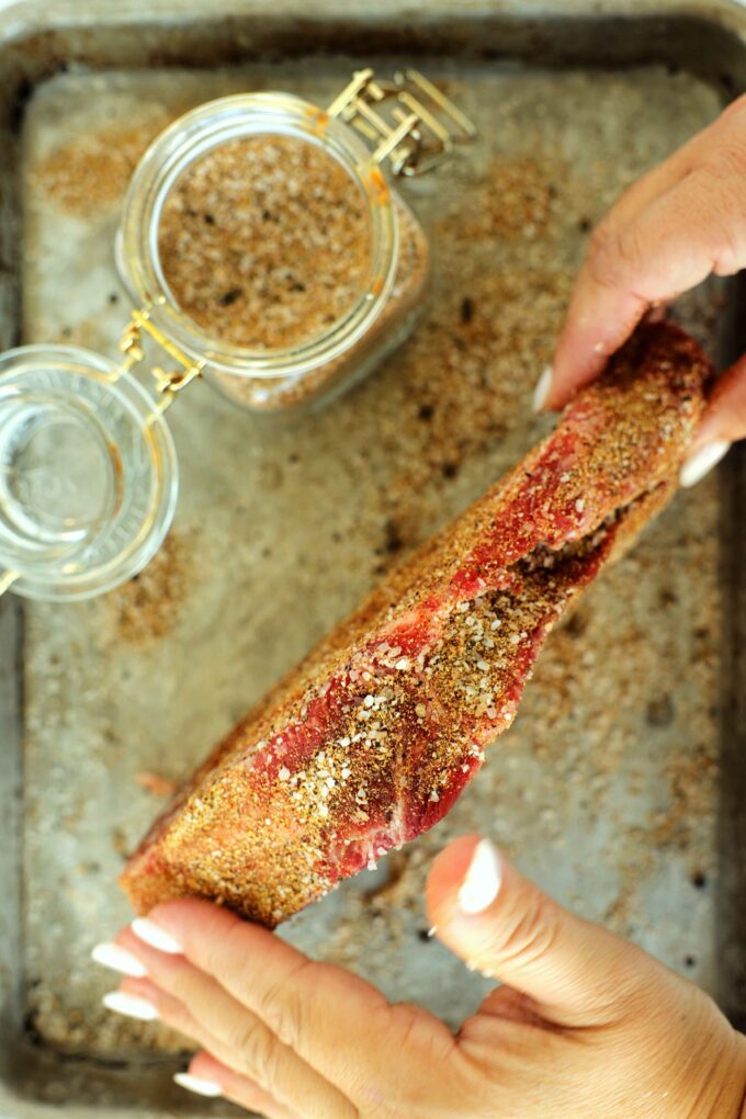 Showing the thickness of an uncooked teak with steak seasoning