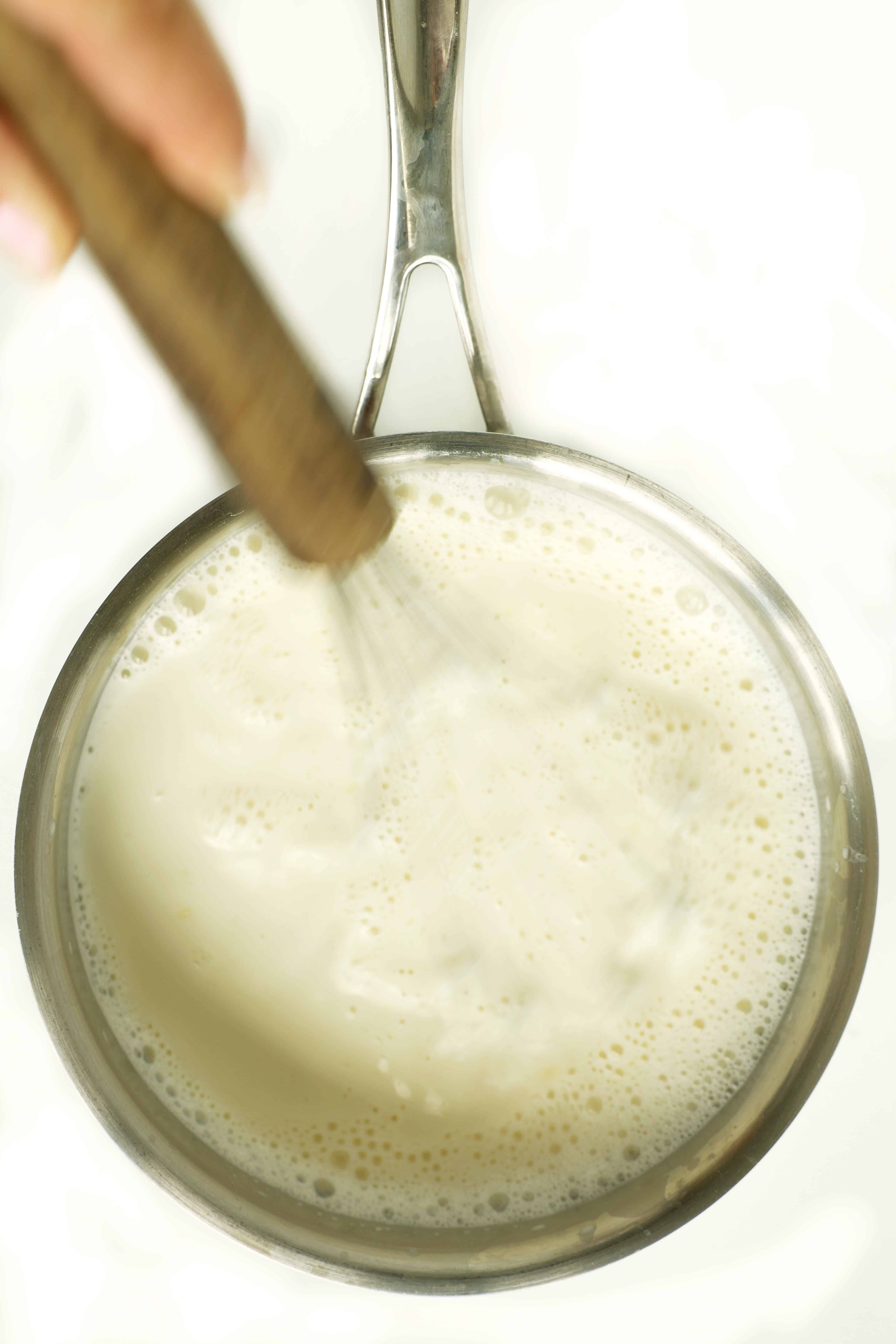 Mixing ingredients together for white hot chocolate in a pot