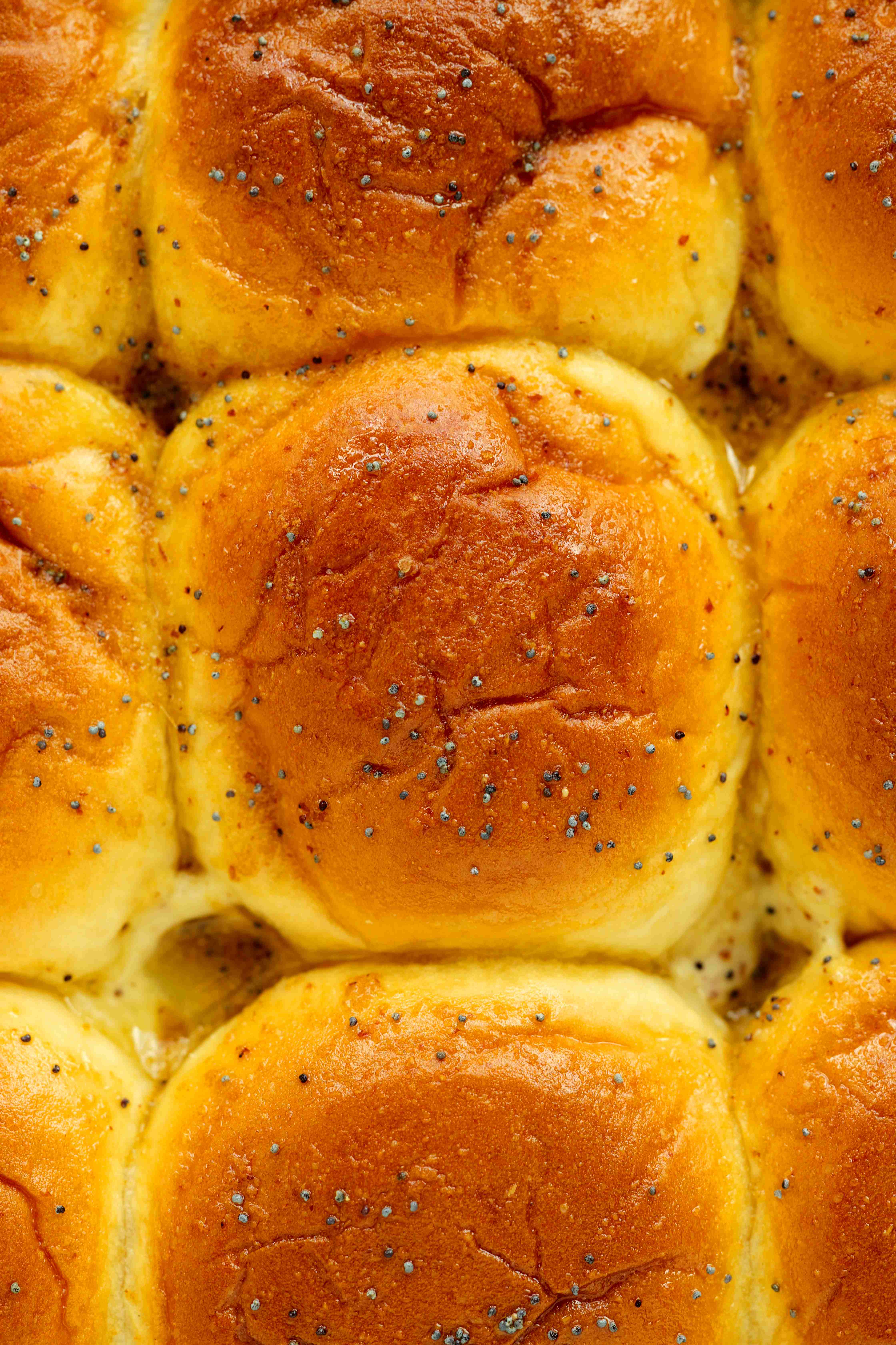 Golden brown Hawaiian rolls baked with butter and poppy seeds for roast beef sliders.