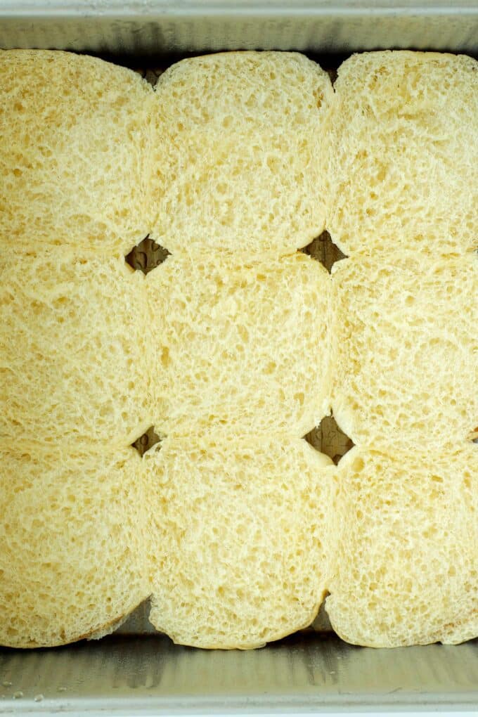 Bottom halves of Hawaiian rolls in a baking dish ready to assemble roast beef sliders.