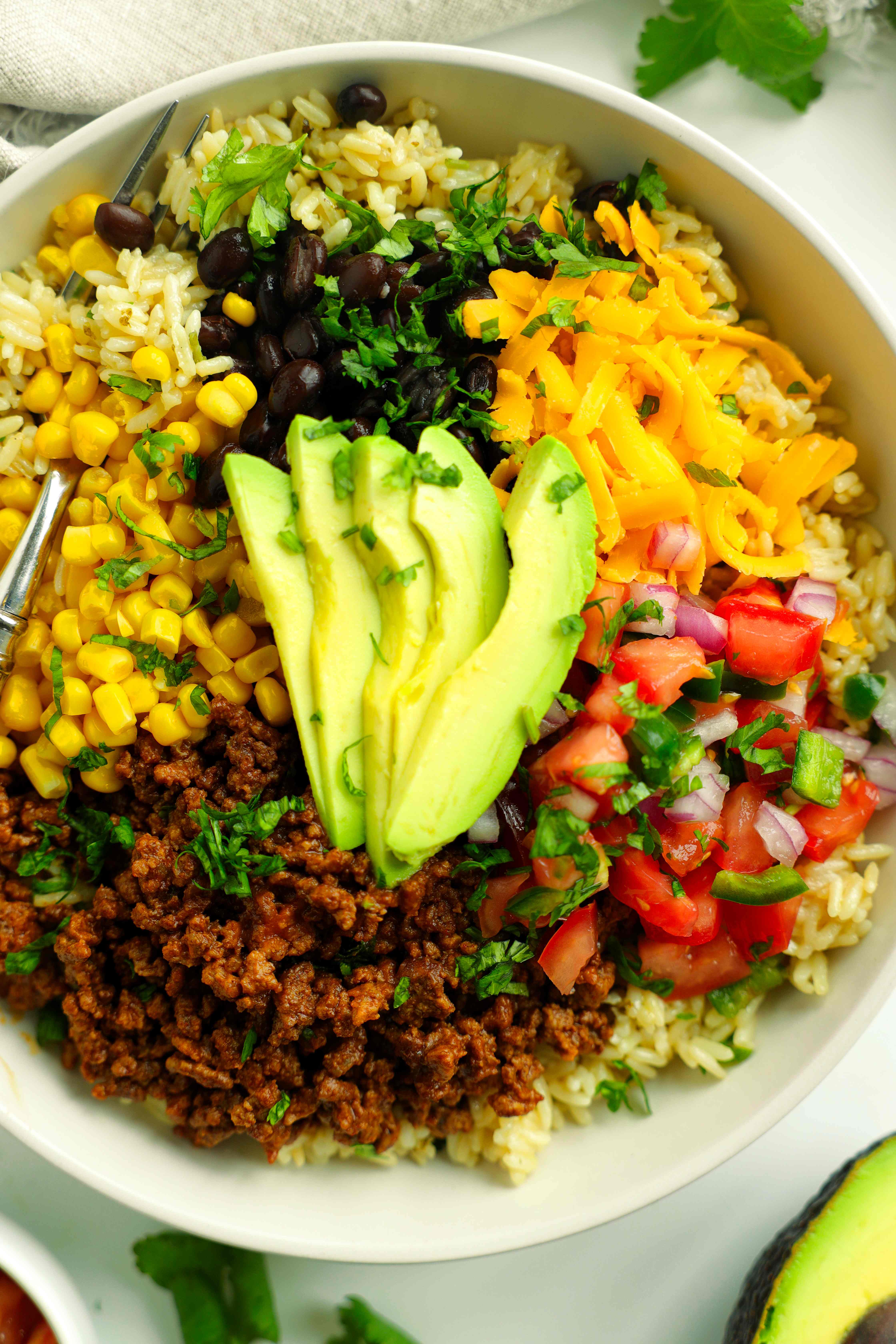 Close-up taco bowls with taco meat, cilantro lime rice, and fresh toppings