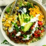 Easy beef taco bowl topped with avocado, cheese, pico de gallo, and creamy cilantro sauce