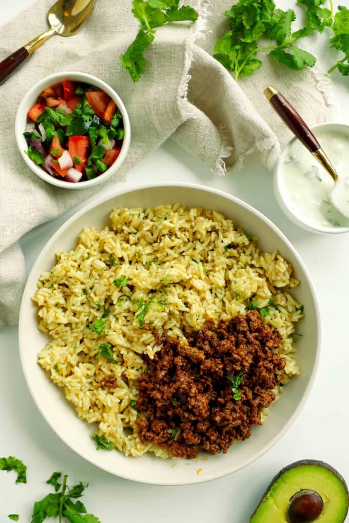 Taco bowl assembly with cilantro lime rice and taco meat.