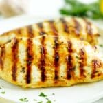 Close-up of grilled chicken breast with charred grill marks and garlic herb marinade