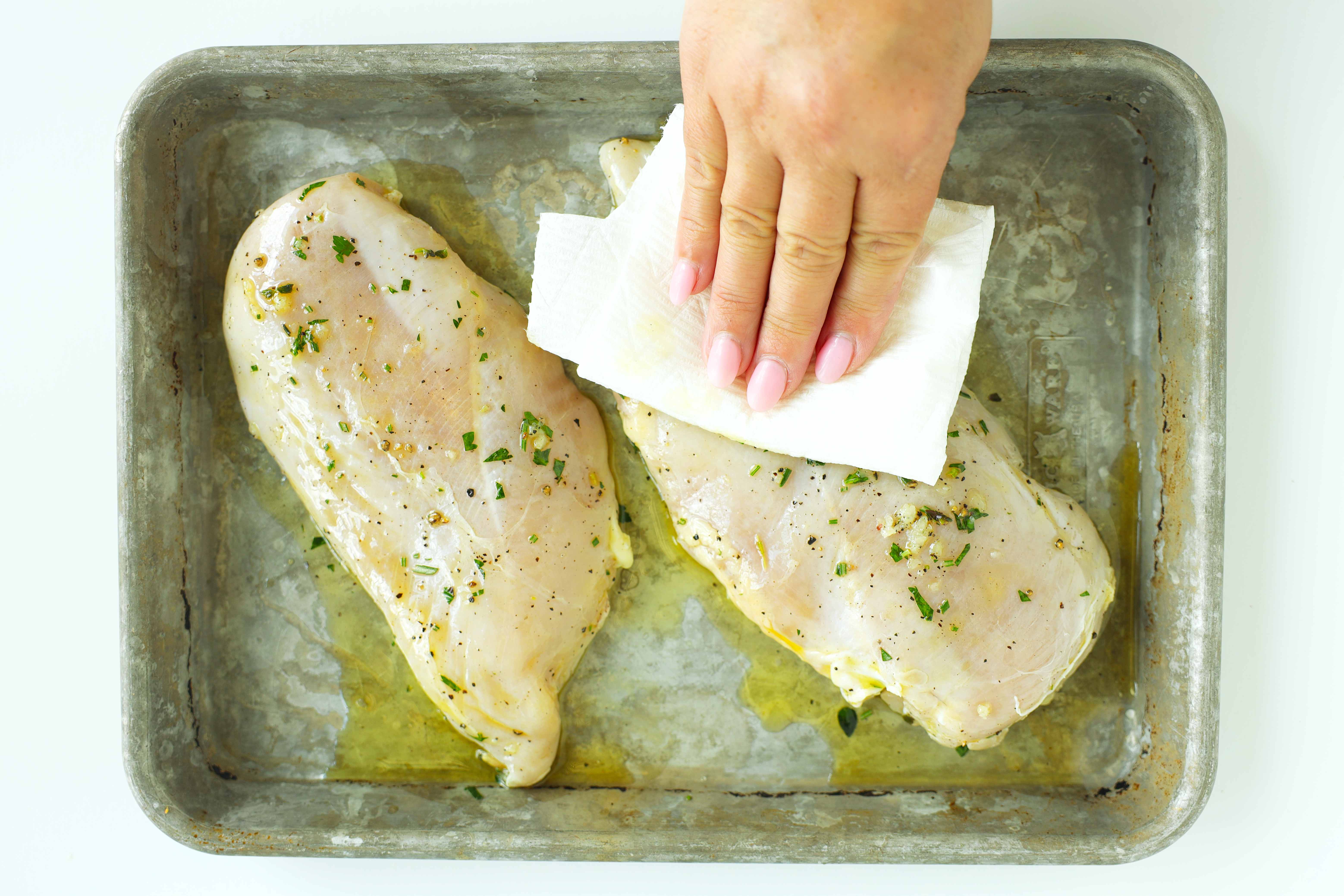 Patting marinated chicken breasts dry with a paper towel before cooking to help them brown evenly