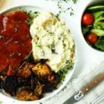 Juicy BBQ pork chops served with mashed potatoes and caramelized Brussels sprouts.