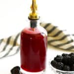Bottle of homemade blackberry simple syrup with fresh blackberries
