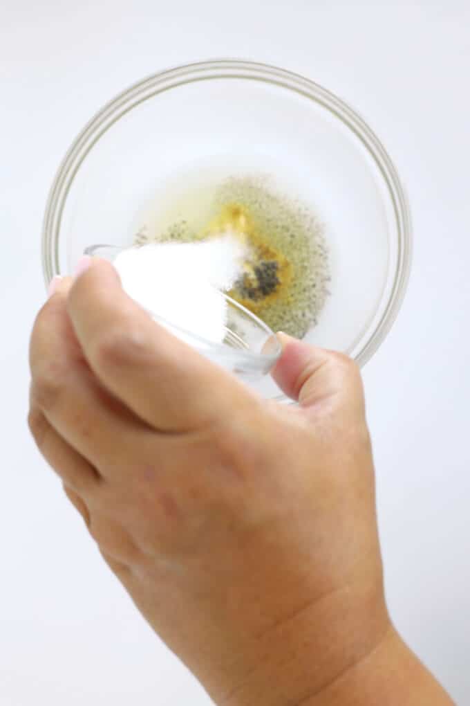 Adding granulated sugar to Dijon mustard and vinegar for homemade Dijon dressing