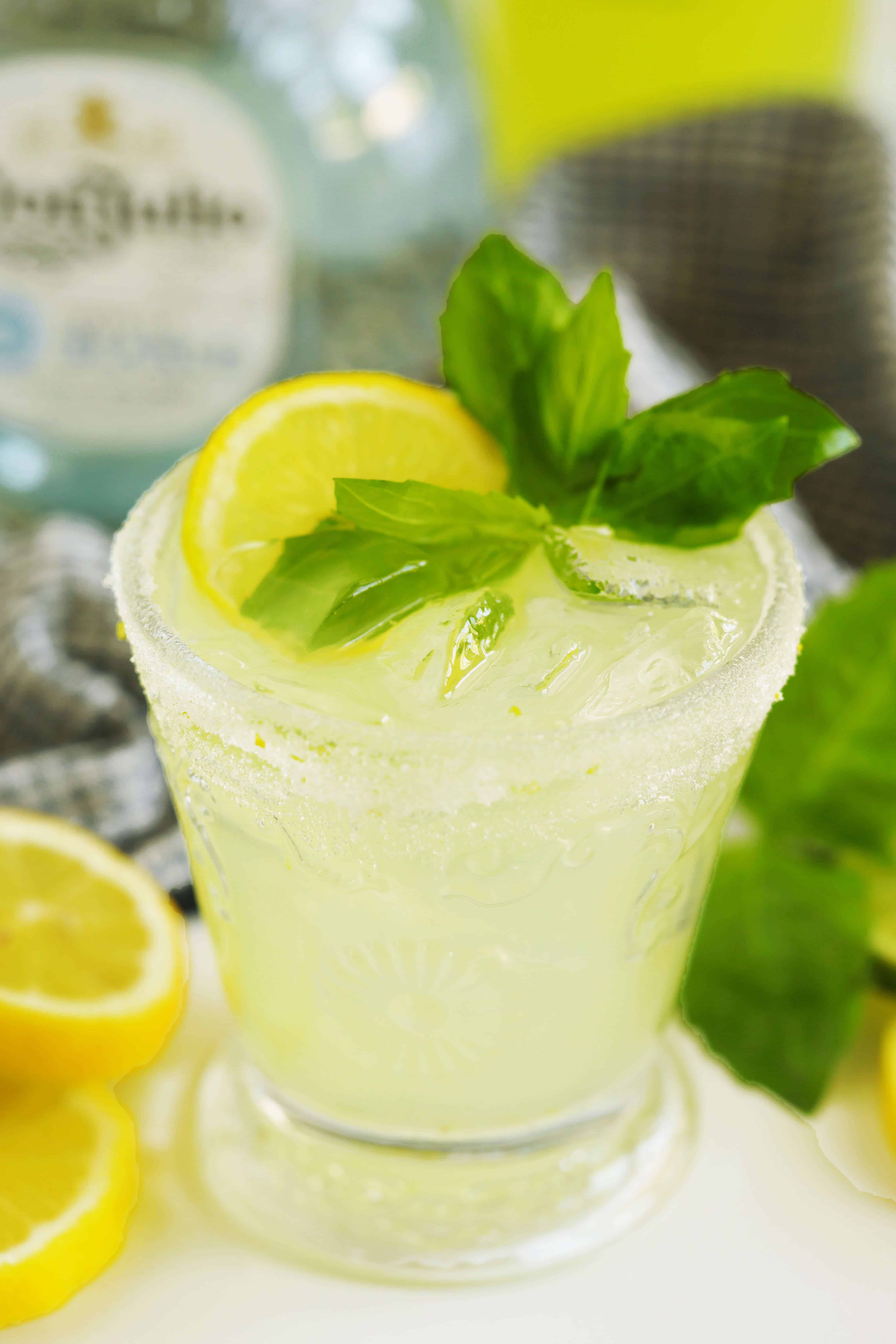 Close-up limoncello margarita with ice, lemon, basil, and a sugar rim