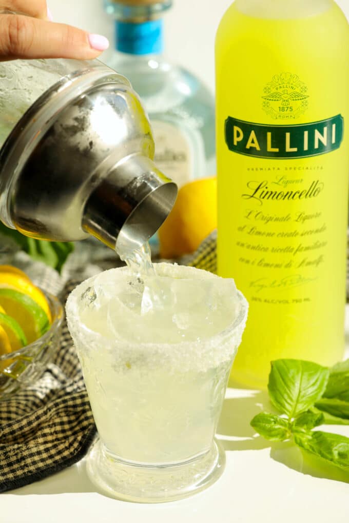 Limoncello margarita being poured from a cocktail shaker over ice
