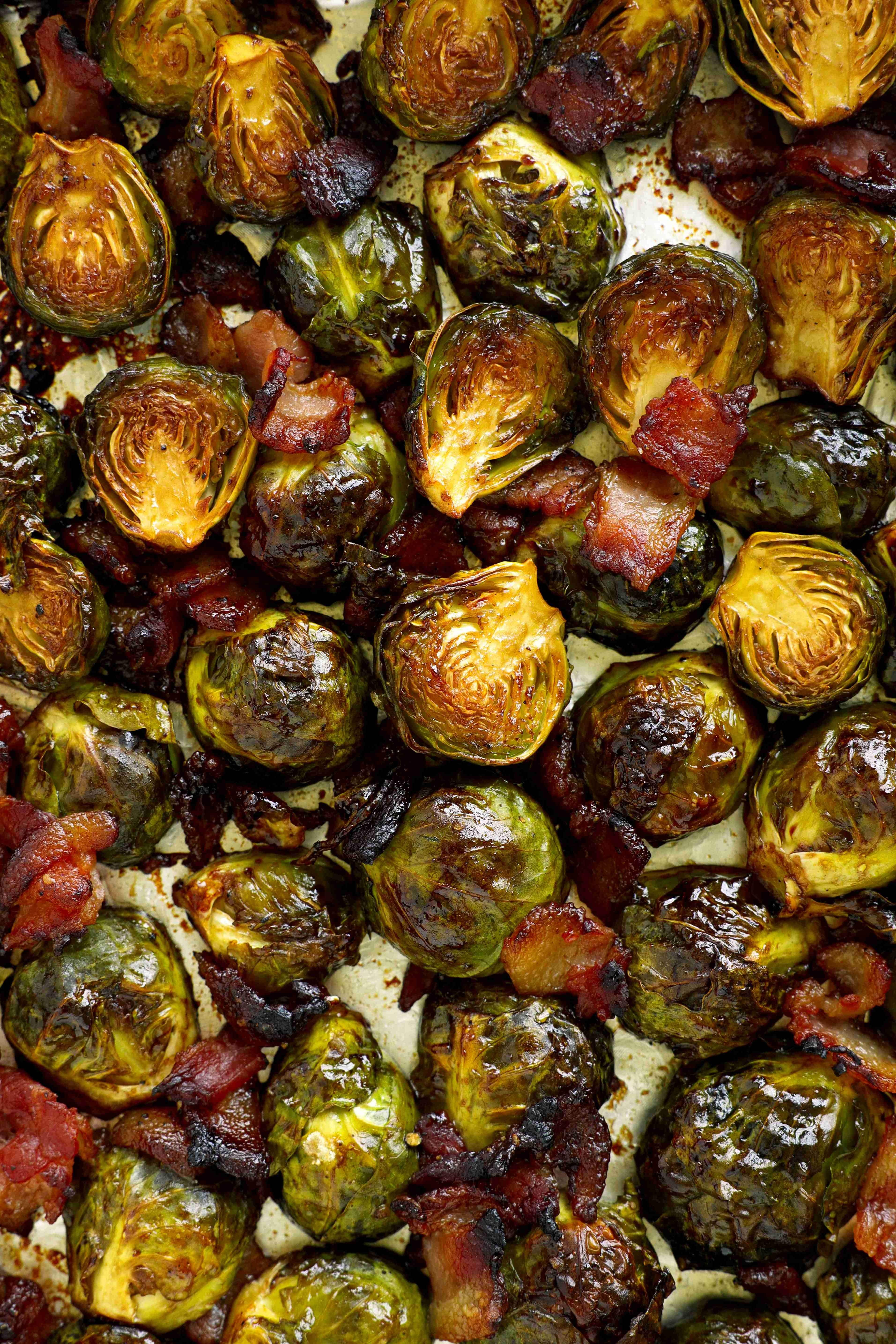 Overhead view of roasted Brussels sprouts with bacon and balsamic glaze on a sheet pan