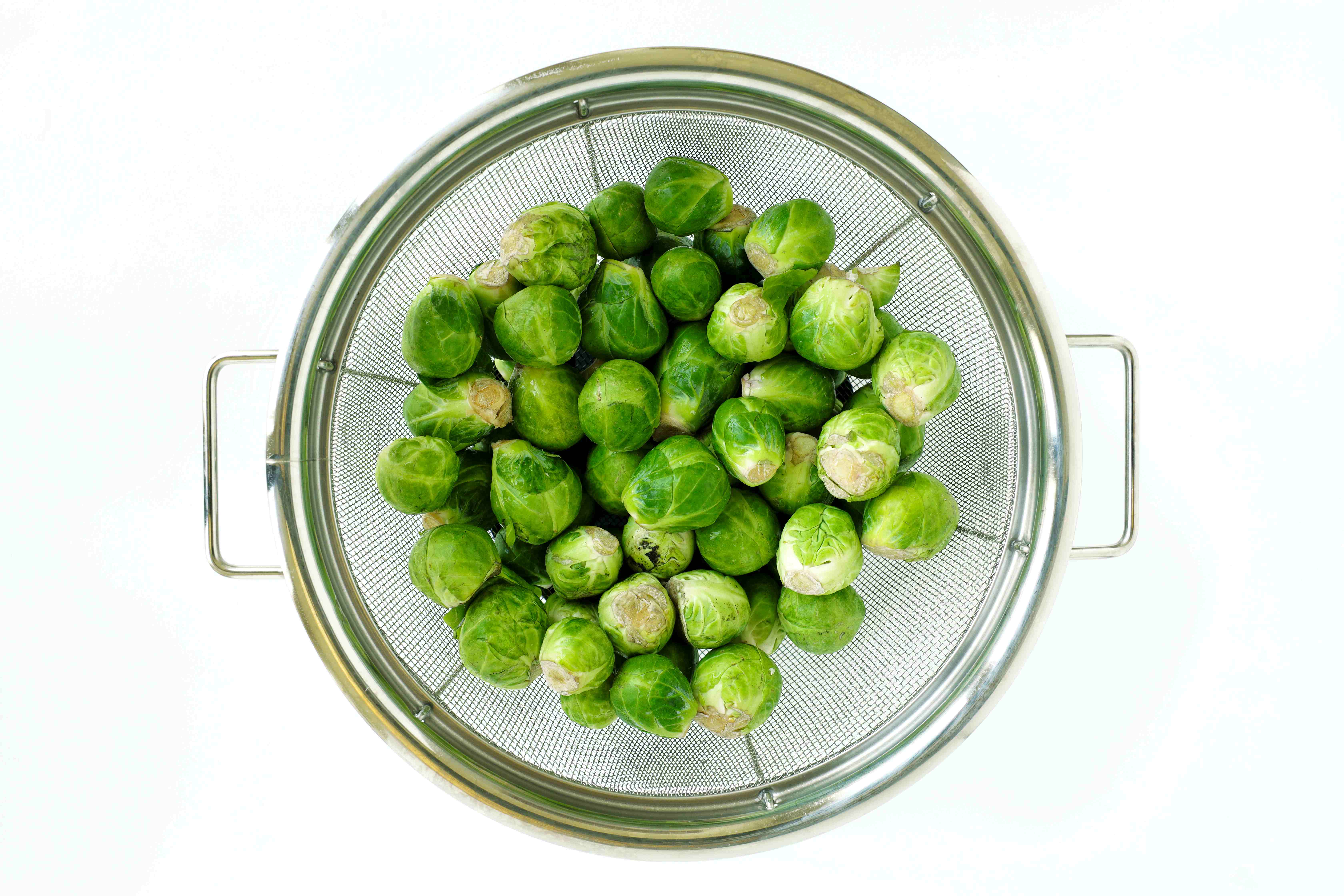 Fresh Brussels sprouts in a metal colander