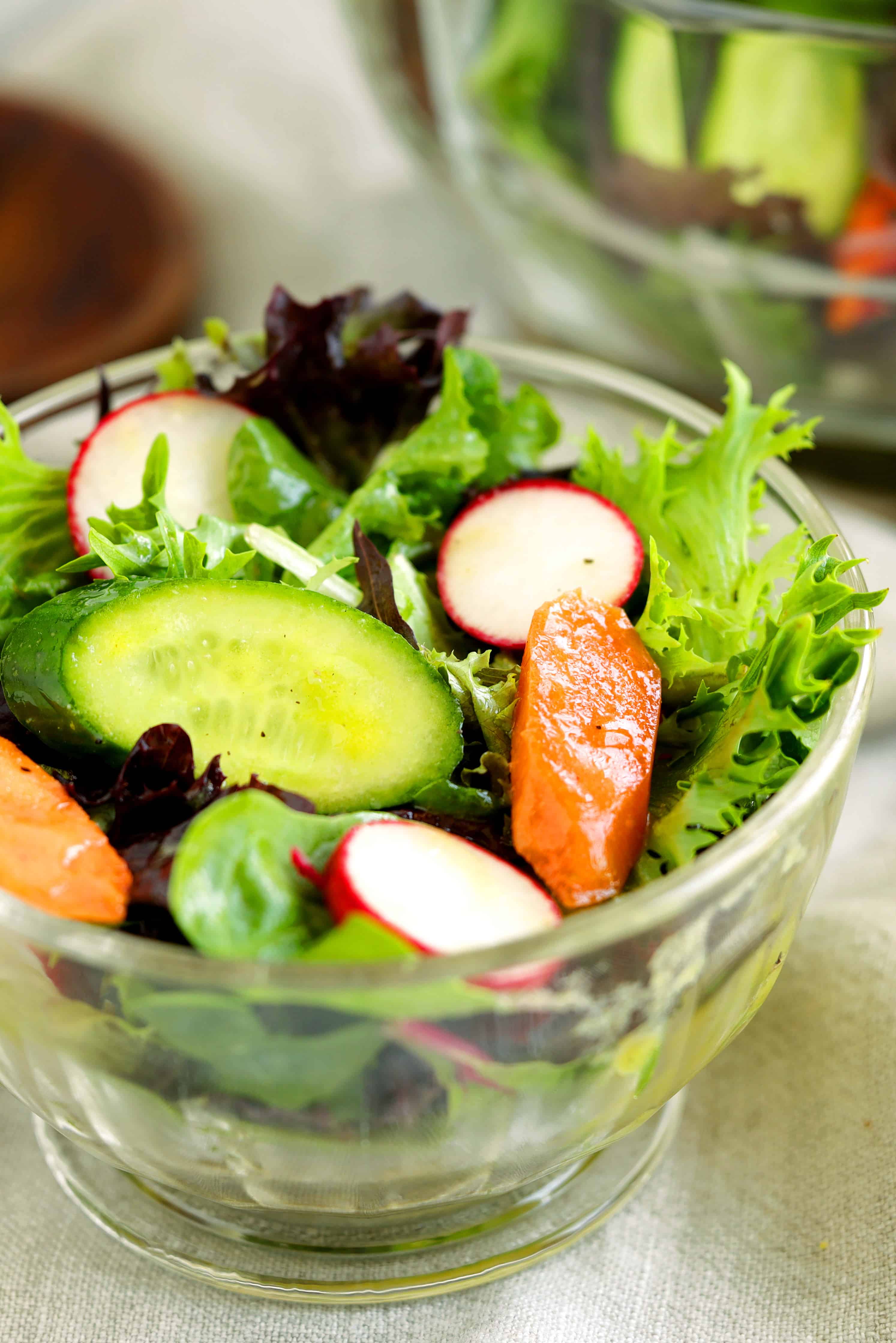 Close-up of spring mix salad with sliced cucumber, radishes, carrots, and mixed greens