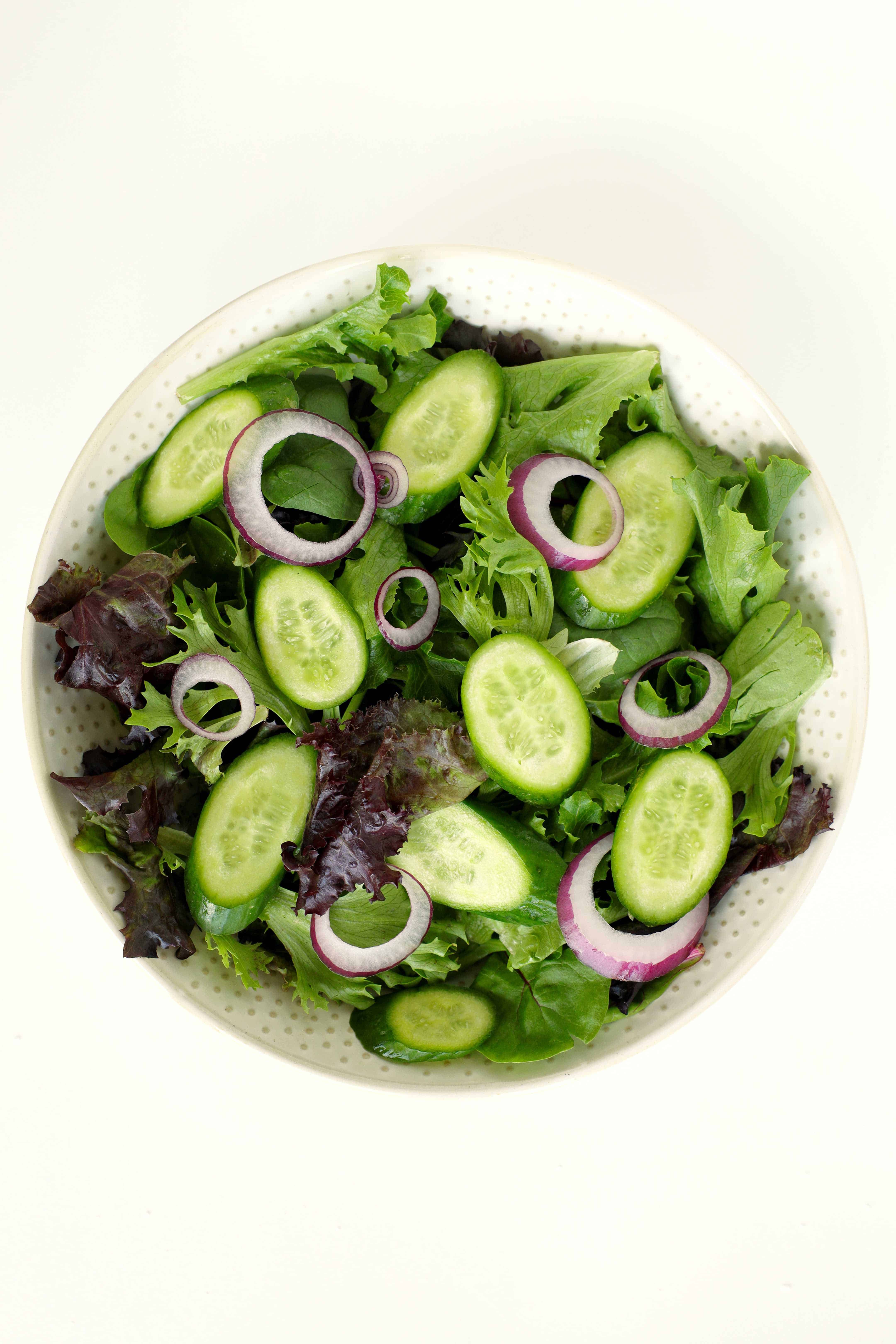 Spring mix salad with sliced cucumbers and red onion