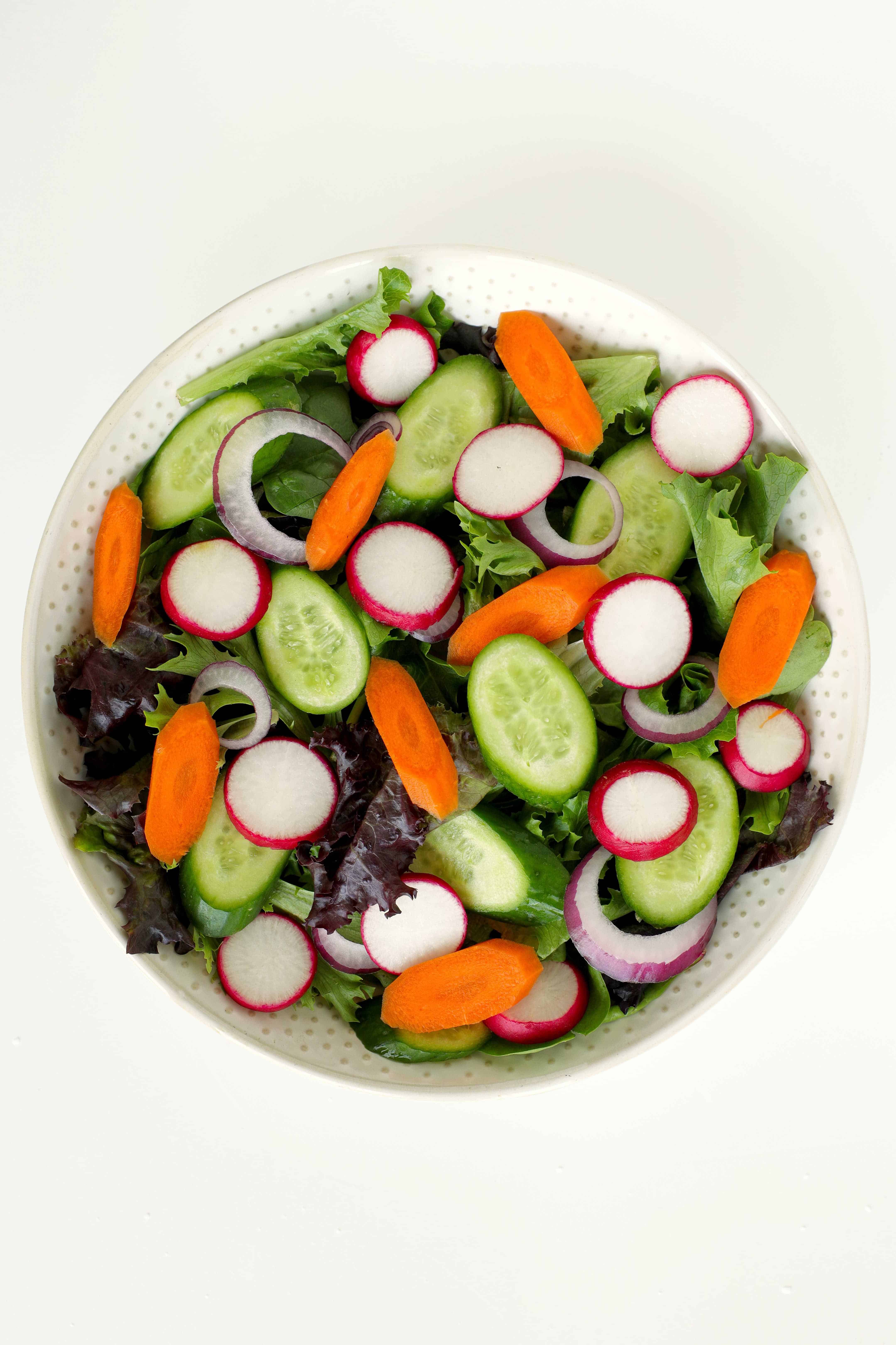 Spring mix salad with cucumbers, red onion, radishes, and carrots